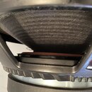 Detailní pohled na reproduktor s černou membránou a kovovým rámem. Povrch rámu vykazuje drobné oděrky a prach. Na fotografii nejsou žádné viditelné z…