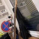 Fotografie zachycuje modrou elektrickou kytaru z pohledu zespodu na hmatník a hlavu. Na hlavě nástroje není žádný viditelný nápis ani logo. V pozadí…