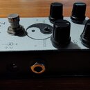 Kytarový efekt pedál v stříbrném provedení s černými boky. Na horní straně je nápis Zendrive a Hermida Audio USA, symbol jin-jang a čtyři černé otočn…