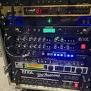 Sestava rackového vybavení v kovovém case na kolečkách. Jsou zde zařízení s nápisy: the t.racks VM-100, Marshall JMP-1 VALUE PRE-AMP, LINE 6, ENGL TU…