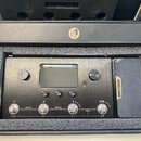 Černý kytarový procesor s nápisem AMPERO Guitar Multi-Effects Processor v originální krabici s pěnovou výplní. Zařízení má centrální displej, několik…
