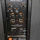 Zadávací panel černého aktivního reproduktoru s nápisem PRX718XLF. Panel obsahuje přepínače POLARITY, PASS THRU, kontrolky Signal a Limit, potenciome…
