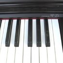 Detail klaviatury s černými a bílými klávesami. Nad klávesami je černý panel s nápisy STEREO SAMPLING a AP-25. Na některých černých klávesách jsou vi…