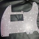 Bíle perleťový pickguard pro elektrickou kytaru s texturou připomínající opaleninu. Díl má obdélníkový výřez pro snímač a několik malých otvorů pro š…