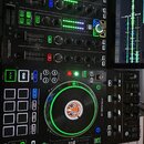 Černý DJ kontrolér s integrovaným displejem, na kterém je zobrazena zvuková vlna. Na přístroji je vidět nápis PRIME 4 a v levém horním rohu označení…