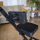 Černá nastavitelná židle s polstrováním z koženky. Na opěrce zad je viditelné logo „frameworks“. Konstrukce je z černého kovu s několika otvory pro r…