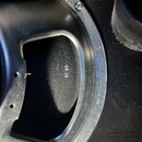 Detailní pohled na zadní část kovového reproduktoru stříbrné barvy. Na černém povrchu je bílý nápis 31 95 a na vnějším okrahu rámu je vyražen nápis M…