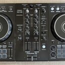 Černý DJ set tvořený dvěma kontrolérymi a centrálním mixérem. Na středovém panelu jsou nápisy PERFORMANCE CONTROLLER DDJ-400, rekordbox a Pioneer DJ.…