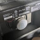 Zadní strana černého reproduktorového komba s koženkovým povrchem. Na zadním panelu je bílý nápis Harley Benton, logo ETL a CE s číslem Intertek 3085…