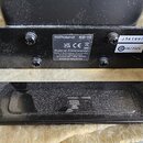Černý kovový držák s nálepkami. Na hlavní nálepce je uveden text Roland KD-10, loga UK CA a CE, dále nápis Roland Corporation 2036-1 Nakagawa, Hosoe-…