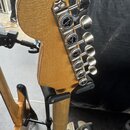Zadní strana hlavy kytary s přírodním dřevem a chromovanými ladicími kolíky. Na každém kolíku je viditelný nápis GOTOH a text LOCKING. Povrch dřeva v…
