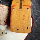 Záběr na zadní stranu dřevěného krku elektrické kytary. Je zde nápis MADE IN JAPAN a sériové číslo Q028168. Vertikálně je vyražen kód ST-57 D. Povrch…