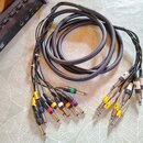 Černý vícežilní kabel zakončený na obou koncích sadou jack konektorů. Jedna strana má konektory s barevnými značkami (žlutá, modrá, červená, zelená,…