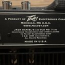 Detailní záběr na černý štítek s bílým textem a dekorativním rámem. Na štítku je nápis A PRODUCT OF Peavey ELECTRONICS CORP., MERIDIAN, MS U.S.A., WW…