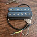 Černý humbucker s dvěma řadami šesti polových magnetů. Na spodní straně je viditelná bílá nálepka s nápisem UNDER ONE OF THE FOLLOWING U.S. PATENTS:.…