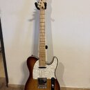 Elektrická kytara typu Telecaster s hnědým slunečním odstínem (sunburst) a výraznou strukturou dřeva. Na hlavě hmatníku je bílý nápis BACY, korpus má…