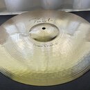 Zlatavý kovový činel s viditelným rýhováním po celém povrchu. Na horní části je nápis "Paiste" a níže označení "Power Crash 16"". Povrch je čistý a b…