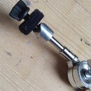 Kovový držák s teleskopickým ramenem a dvěma svěrkacími mechanismy. Horní část je opatřena černým plastovým knoflíkem a černou pěnovou vložkou. Na př…