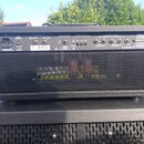 Zadní strana kytarového zesilovače v černém provedení s kovovou mřížkou. Na zadním panelu jsou viditelné nápisy EFFECTS LOOP, FOOTSWITCH, BIAS JACKS…