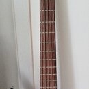 Elektrická basová kytara s pěti strunami a korpusem v černé barvě s přechodem do hnědé. Na hlavě je bílý nápis RockBass a pod ním menší, nečitelný te…