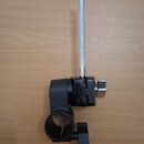 Černý kovový držák s připevněným stříbrným, texturovaným kovovým kolíkem. Součástí je utahovací šroub s knoflíkem v dolní části a chromovaný šroub s…