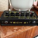 Černý kytarový pedál s žlutými nápisy. Na horní straně jsou ovládací knoflíky s popisky LEVEL, BLEND, PRESENCE, TREBLE, BASS a DRIVE. Na přední stran…
