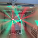 Dvě svítící party lampu umístěné na bílých stojankách v prostoru garáže. Zařizení vyzařují červené a zelené paprsky světla. Na přístrojích nejsou vid…