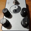 Kytarový efekt v stříbrném kovovém provedení s černými ovládacími knoflíky. Na horní straně je nápis Zerodrive a Hermida Audio USA, ve středu se nach…