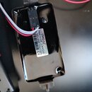 Fotografie zachycuje zadní stranu černé elektroniky kytary. Na bílé nálepce je uveden text MADE IN USA, EMG-57 a 4305.01, dále sériové číslo 21145136…