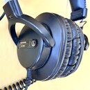 Černá uzavřená sluchátka s polstrováním z černé syntetické kůže. Na vnější straně mušle je bílý nápis audio-technica a pod ním ATH-PRO5X, vedle nich…