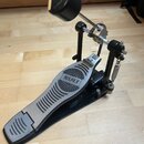 Fotografie zobrazuje černý a stříbrný basový pedál. Na šlapce je viditelný nápis MAPEX v oválném rámu. Pedál vykazuje mírné známky používání a opotře…