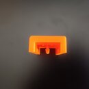 Na fotografii je malý, oranžový plastový dílek obdélníkového tvaru s výřezem v dolní části. Povrch je hladký a bez viditelných nápisů či log. Dílek v…