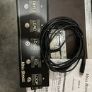Černý přepínač kanálů s nápisy MESA/BOOGIE a FU-3. Na horní straně jsou umístěna tlačítka s označením RHY 1, RHY 2, LEAD, LD-EQ, EQ a LOOP. K zařízen…
