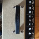 Kytarový kombo zesilovač v béžovém vinylu s černým ovládacím panelem a černou rukojetí. Na panelu jsou nápisy Roland, BluesCube Stage, POWER CONTROL…