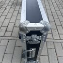 Černý transportní kufr s hliníkovými hranami a kovovými rohy. Na krátké straně jsou vidět dva zámky, jeden z nich je opatřen klíčem. Povrch hliníkový…