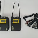 Dvě černé bezdrátové vysílačky s anténami a přiloženým kabelem s konektory. Na levém zařízení je nápis LENS 50, WIRELESS MICROPHONE TX a logo T.R. Sp…