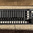 Černý DMX kontrolér s nápisem eurolite DMX MOVE CONTROL 512. Zařízení obsahuje 16 posuvníků s bílými popisky čísel od 1/R do 16, řadu bílých tlačítek…