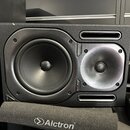Černý studiový monitor s dvěma reproduktory. Mezi nimi je nápis TRUTH BOOTHA a kontrolka s označením PWR. Před monitorem leží černý pěnový podložkový…