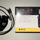 Na fotografii je bezdrátový systém pro kytaru značky JOYO, model JW-03, v originálním balení. Sada obsahuje černý vysílač s nápisem JOYO TRANSMITTER…