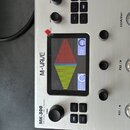 Stříbrný efektový procesor s nápisem M-WAVE a označením MK-300 AMP Modeler / Effects Processor PARA. Zařízení má centrální displej zobrazující ladicí…
