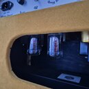 Detailní pohled do vnitřku přístroje s dvěma elektronkami. Na spodním černém povrchu je bílá nálepka s logem MOD a nápisem Model: P-AMP-20W. Horní pa…