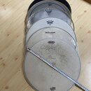 Sestet náhradních bubnových koží položených na dřevěné podlaze. Na kožích jsou viditelné nápisy EVANS, REMO (dvakrát), Millenium a MAPEX, u spodní ko…