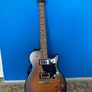 Elektrická kytara s polodupatým korpusem v tmavě hnědém sunburst provedení. Na hlavě je zlaté logo Godin a nápis SUMMIT LTD. Nástroj má dva humbucker…