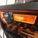 Detailní pohled na přední panel rackového zařízení v oranžovém provedení. Uprostřed je podsvícený nápis Eleven | RACK, vlevo jsou tlačítka EDIT / BAC…