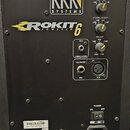 Zadní strana černého aktivního monitoru s nápisy KRK SYSTEMS a ROKIT POWERED 6. Jsou zde tři žluté regulační knofíky s popisky HF LEVEL ADJUST, LF LE…