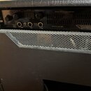 Zadní panel kytarového komba v černém vinylu. Na panelu jsou nápisy NOMAD 55 ALL TUBE AMPLIFIER, PATENTED 4,211,693 a logo MESA ENGINEERING. Jsou zde…