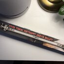 Fotografie znázorňuje krabici s příslušenstvím pro bicí. Na obalu je zobrazen kovový hřídel s nápisem PIV6 TRICK RETROFIT DRIVE SHAFT a logo TRICK DR…