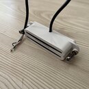 Bílý humbucker s nápisem Seymour Duncan na povrchu. Nástroj má připojené černé kabely a několik volných barevných vodičů. Povrch je hladký, bez vidit…