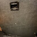 Zadní strana černého kytarového komba s povrchem z texturovaného vinylu. V horní části je umístěn ovládací panel s nápisy 1960B 4x12, MADE IN ENGLAND…