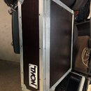Černý transportní kufr s hliníkovými hranami a kovovými rohy. Na přední straně je nalepený bílo-černý štítek s nápisem THON a menším textem pod ním,…
